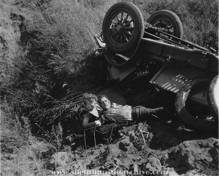 Edna Murpy pulls Charles Parrott (Charley Chase) from an automobile crash in HER DANGEROUS PATH (1923)
