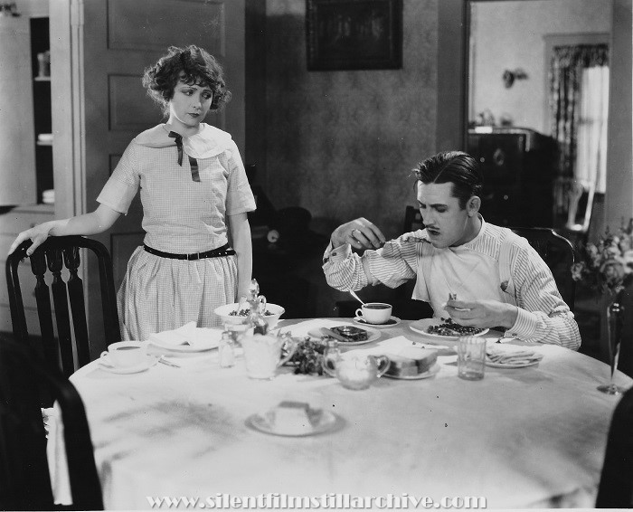 Edna Murpy watches Charles Parrott (Charley Chase) eat dinner with his knife in HER DANGEROUS PATH (1923)